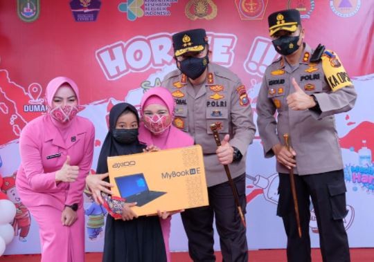 Ketua Bhayangkari Riau Nindya Iqbal memberikan hadiah laptop kepada peserta vaksin anak-anak. (Foto: Polda Riau)