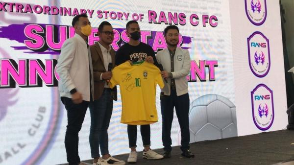 RANS Cilegon FC Raffi Ahmad Ronaldinho RANS Cilegon FC milik Raffi Ahmad (paling kiri) resmi mendatangkan Ronaldinho. Acara peresmian itu dilakukan dengan cara memamerkan jersey sang legenda Timnas Brasil di Jakarta, Selasa (29/3/2022). (Foto: MPI/Melati Pratiwi)