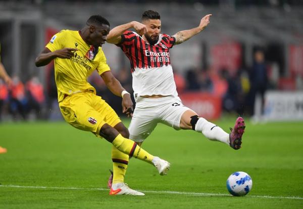 Pemain Bologna, Adama Soumaoro meloloskan bola dari kejaran striker AC Milan, Olivier Giroud dalam laga Liga Italia 2021/2022 di Stadion San Siro, Selasa (5/4/2022). (Foto: REUTERS/Daniele Mascolo)