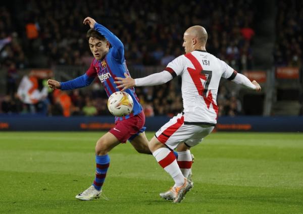 Gelandang energik Barcelona, Gavi berusaha lolos dari kawalan pemain Rayo Vallecano, Isi Palazon dalam laga Liga Spanyol 2021/2022 di Stadion Camp Nou, Senin (25/4/2022). (Foto: REUTERS)