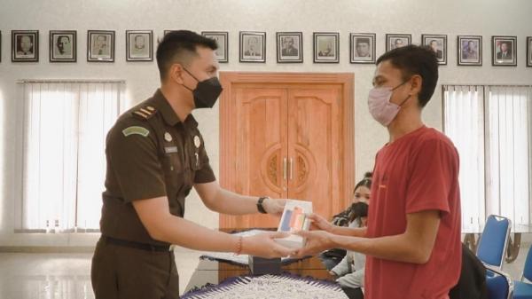Dapat HP Tersangka kasus pencurian ponsel mendapat hadiah kejutan dari Kejari Badung setelah perkaranya dihentikan. (Foto: iNews.id/Dewi Umaryati)