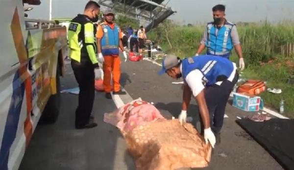 laka bus jombang4 Petugas mengevakuasi korban tewas laka bur pariwisata di Tol Jombang-Surabaya, Senin (16/5/2022). (Foto: iNews.id/Sholahudin).