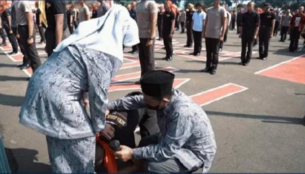 Bintara 2 IG Fadil Imran Anak sopir angkot Depok yang menjadi Bintara Polri mencium kaki orang tuanya usai pelantikan. (Foto Instagram Kapolda Metro Jaya).