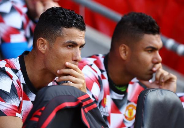 Pemain Manchester United, Cristiano Ronaldo dan Casemiro duduk di bench saat timnya melawan Southampton pada laga Liga Inggris 2022/2023 di Stadion St Mary, Sabtu (27/8/2022). (Foto: REUTERS)