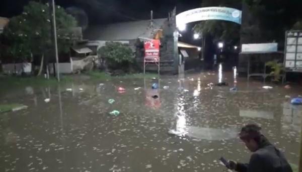 Banjir rob di Pantai Lebih, Gianyar menyebabkan air laut meluber ke Jalan Bypass Ida Bagus Mantra. (Foto: iNewsTV/Ketut Catur)