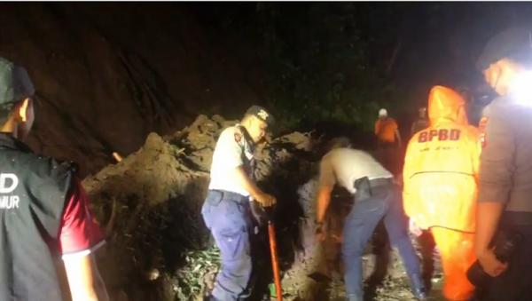 longsir Petugas bersama warga membersihkan material longsor yang menutup jalan Jember-Banyuwangi, Senin (7/11/2022). (Foto: iNews.id/Bambang Sugiarto).