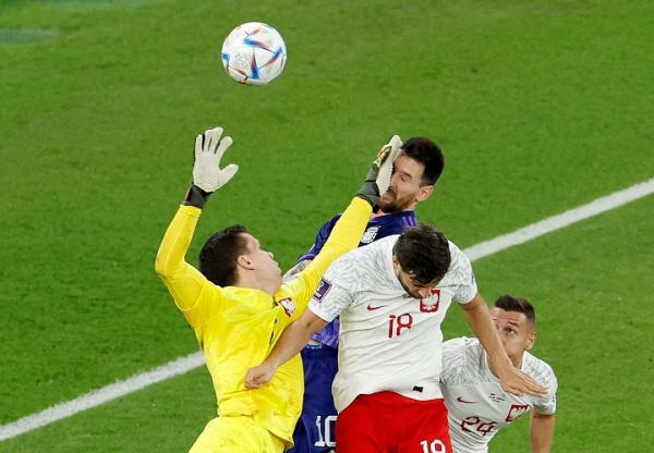 Kiper Polandia, Wojciech Szczesny berduel udara dengan kapten Argentina, Lionel Messi pada laga Grup C Piala Dunia 2022 di Stadion 974, Doha, Kamis (1/12). Argentina mendapatkan penalti lewat kejadian tersebut. (Foto: REUTERS)