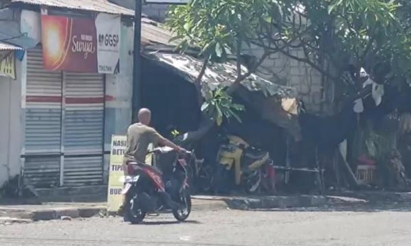 Warga Denpasar menuntun motor karena kehabisan bensin. (Foto: Wira Dana)