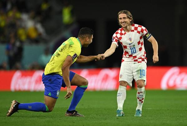 Pemain Kroasia, Luka Modric memberikan uluran tangan kepada pilar Brasil, Casemiro pada laga perempat final Piala Dunia 2022 di Stadion Education City, Jumat (9/12/2022). (Foto: REUTERS)