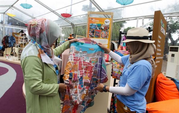 Indah (kanan) saat menawarkan produknya kepada salah satu pengunjung yang hadir di WMM 2022. (Foto: MPI/Aldhi Chandra Setiawan)