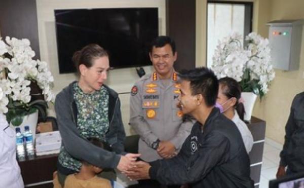 Wisatawan Ditinggal Sopir Taksi Shannahan Dervla Sarah bersalaman dengan sopir taksi online yang mengantarnya, Rizki Hartono. (Foto: Polda Bali)