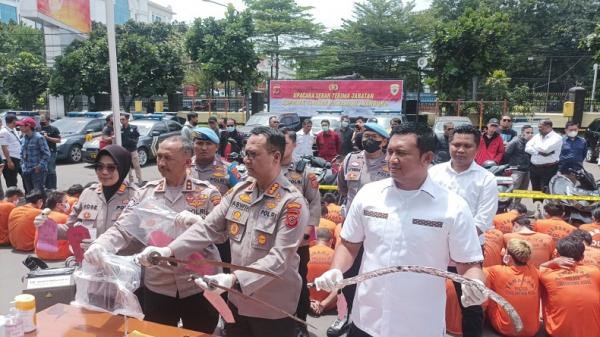 KEJAHATAN JALANAN BANDUNG Kapolrestabes Bandung Kombes Pol Aswin Sipayung didampingi Kasatreskrim AKBP Arief Prasetya menunjukkan senjata tajam yang digunakan para pelaku kejahatan jalanan. (FOTO: iNews.id/AGUS WARSUDI)