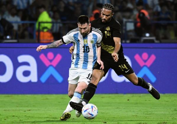 Kapten Timnas Argentina Lionel Messi dikawal ketat pemain Curacao, Kenji Gorre dalam laga persahabatan di Stadion El Monumental, Rabu (29/3/2023). (Foto: Twitter/@Argentina)