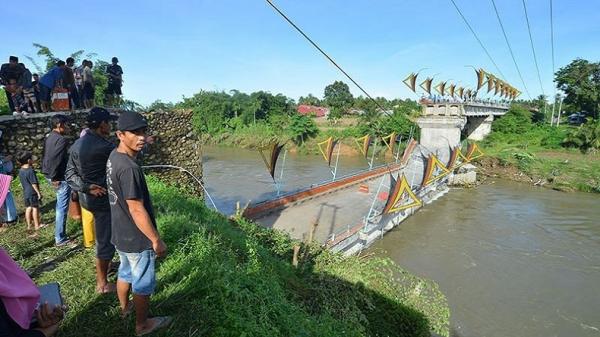 Warga melihat kondisi jembatan ambruk di Kayu Gadang Sikabu, Lubuk Alung, Padang Pariaman, Sumatera Barat, Senin (8/5/2023). Jembatan terpanjang di kabupaten itu yang dibangun dari dana hibah BNPB senilai Rp25,4 miliar. (ANTARA FOTO/Iggoy el Fitra/rw