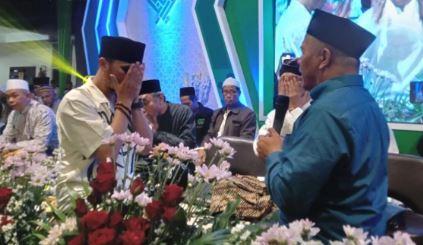 Ustaz Hanan Attaki Baiat ke NU Ustaz Hanan Attaki mengusap mukanya setelah mengucapkan baiat atau ikrar menjadi warga NU di hadapan Ketua PWNU Jatim KH Marzuki Mustamar. (Foto: ist/Instagram Dawuh Guru)
