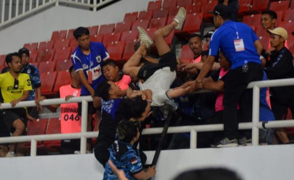 Petugas mengevakuasi seorang suporter yang menjadi bulan-bulanan oknum suporter PSIS di Tribun Timur Stadion Jatidiri, Minggu (20/8) malam. (iNews.id)