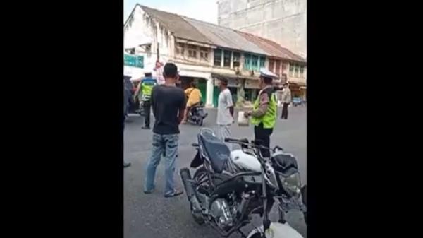 Seorang emak-emak pengendara motor meraung-raung saat terjaring razia polisi di Jalinsum Kotapinang, Labuhanbatu Selatan (Labusel), Sumatera Utara menghebohkan warga sekitar. (Foto: Istimewa).