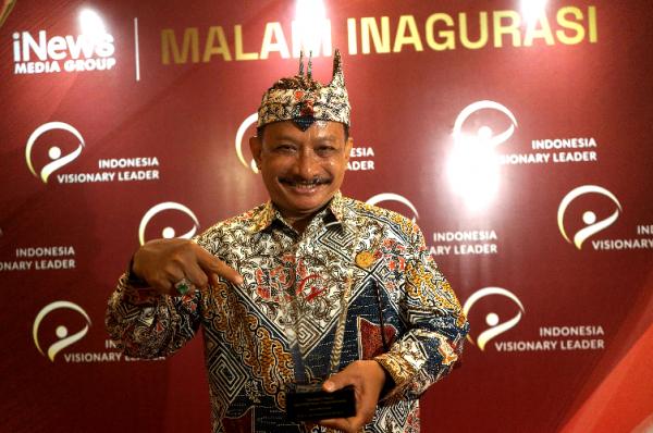 Bupati Situbondo Karna Suswandi IVL 2023_ Bupati Situbondo menunjukkan Plakat Penghargaan IVL 2023. (Foto: iNews Media Group/Aldhi Chandra Setiawan)