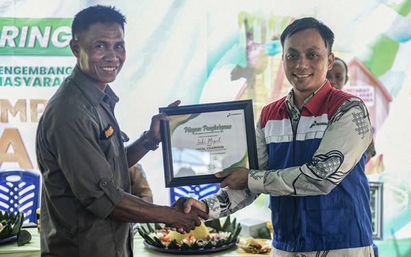 Field Manager Pertamina EP Donggi Matindok Field Ridwan Kiay Demak (kanan) memberikan penghargaan kepada Pengelola Taman Kehati Kokolomboi, Labi Mopok