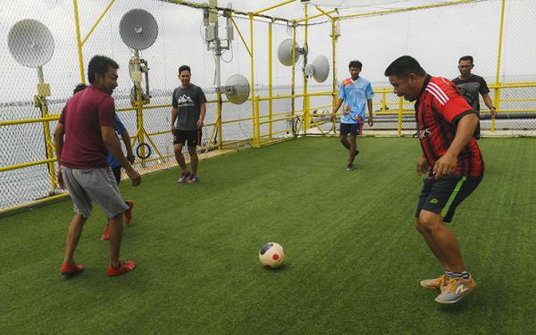 Pekerja Pertamina Hulu Kalimantan Timur (PHKT) bermain bola saat menunggu waktu buka puasa (ngabuburit) di anjungan lepas pantai Yakin Field.