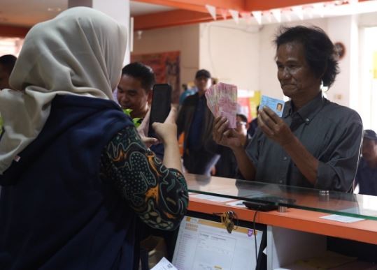 Warga penerima bansos PKH dan sembako semringah mendapat dana bantuan dari pemerintah. (Foto: ist)