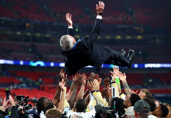 Pelatih Real Madrid Carlo Ancelotti dilempar ke udara oleh para pemainnya saat merayakan juara Liga Champions 2023-2024 di Wembley, London, Minggu (2/6/2024) dini hari WIB. (Foto: REUTERS)
