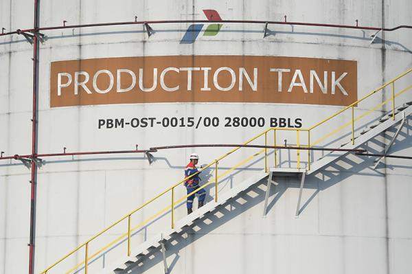 Perwira memeriksa level tangki produksi di Pusat Pengumpul Produksi (PPP) Pertamina EP Prabumulih Field, Sumatera Selatan.