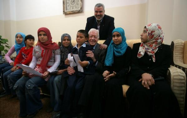 Haniye Dan Jimmy Carter B EPA Ismail Haniyeh (belakang) bersama Presiden ke-39 AS Jimmy Carter (duduk, ketiga dari kanan) dan anak-anak Gaza pada Juni 2009. (Foto: EPA)