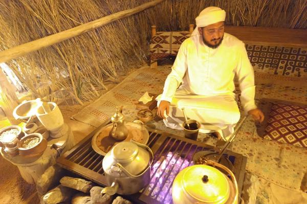safari gurun dubai_kopi arab Seorang pria menyiapkan kopi Arab untuk disuguhkan kepada para wisatawan sebelum menikmati makan malam di tenda mewah ala Bedouin. (iNews.id/Maria Christina Malau)
