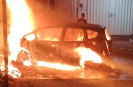 Honda Jazz terbakar usai kecelakaan menabrak pohon dan kios bensin di Kota Malang. (Foto: iNews) 