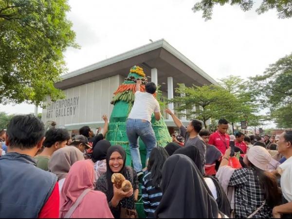 Momen pengunjung rebutan gunungan hasil Bumi di TMII. (Foto: Niko Prayoga)