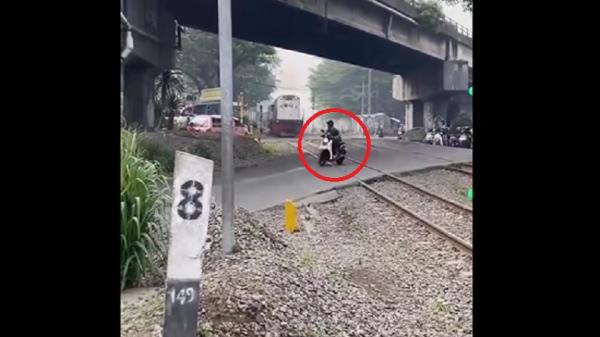 Pemotor Pengendara sepeda motor nyaris tertabrak kereta api di pelintasan sebidang Cimindi, perbatasan Kota Bandung–Cimahi, Jawa Barat. (Foto: Rekaman video warga).
