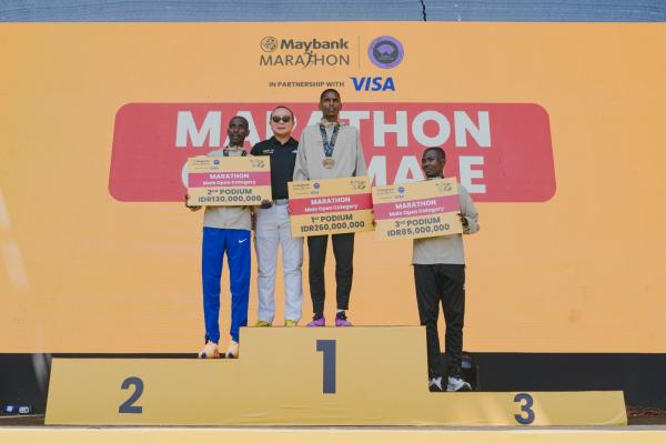 Podium Marathon Open Male Juara 1, 2, dan 3 kategori Marathon Open Male memegang cek hadiah di atas podium.