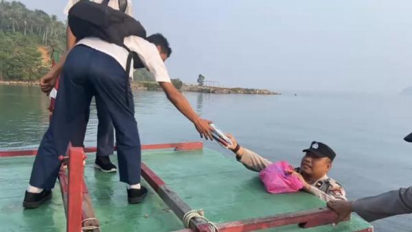 Momen Humanis Polisi di Anambas Bantu Anak Naik Kapal hingga Beri Buku