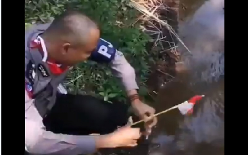 Video Viral, Polisi Botak Ambil Bendera RI yang Tercebur di Selokan